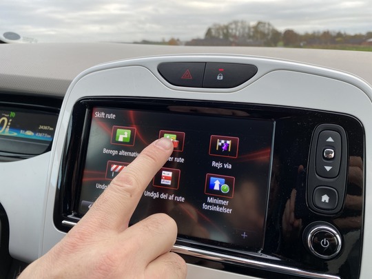 Finger taster på en touchskærm i en bil
